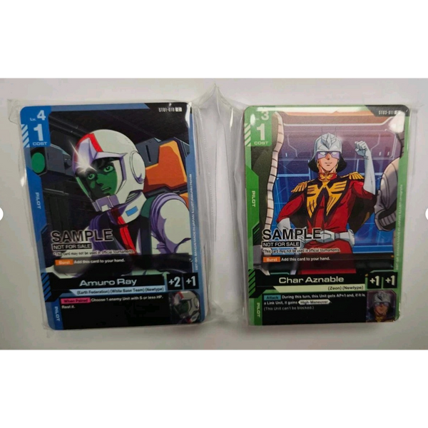 Cartas de demostración Gundam TCG con Amuro Ray en azul y Char Aznable en verde, en sus envoltorios plásticos originales.