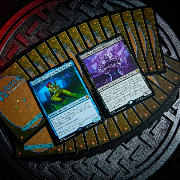 Cartas de Magic: The Gathering de las Tortugas Ninja, incluyendo a April O'Neil y Shredder sobre una base metálica circular.