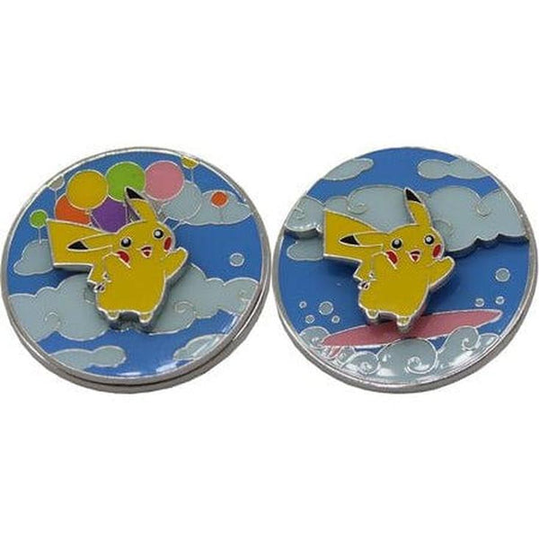 Dos pines metálicos circulares de Pikachu sobre fondo de nubes azules, uno con globos coloridos y otro sobre una tabla.